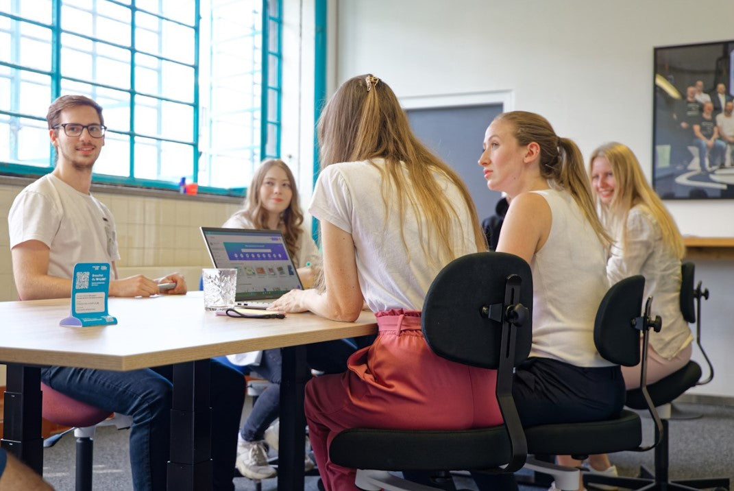 Personen auf Ergonomiestuhl Aurelius beim Tisch sitzend